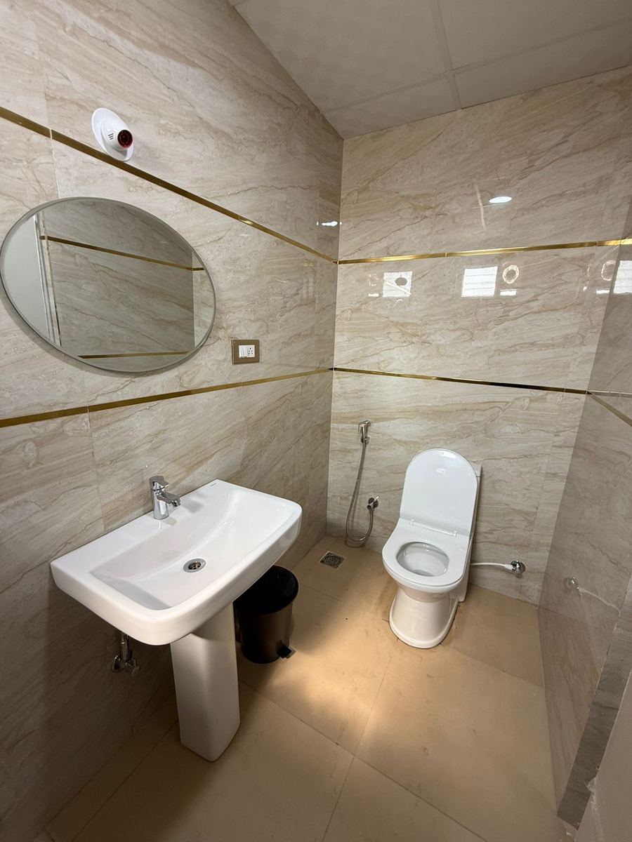 Modern bathroom with marble tiles and gold trim accents
