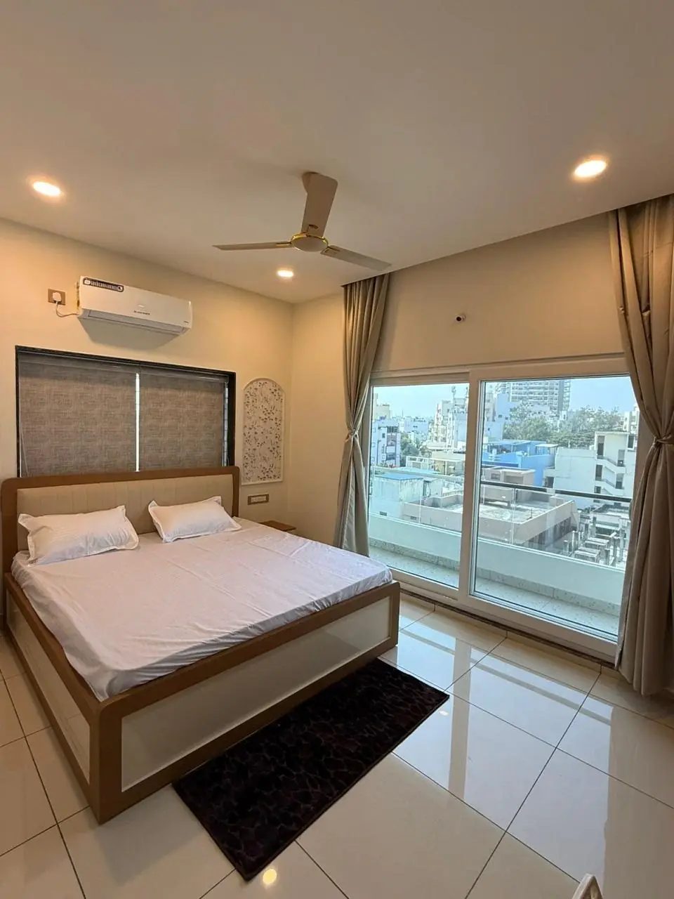 Master bedroom with a king size bed and balcony, a service apartment for new joiners in Hyderabad