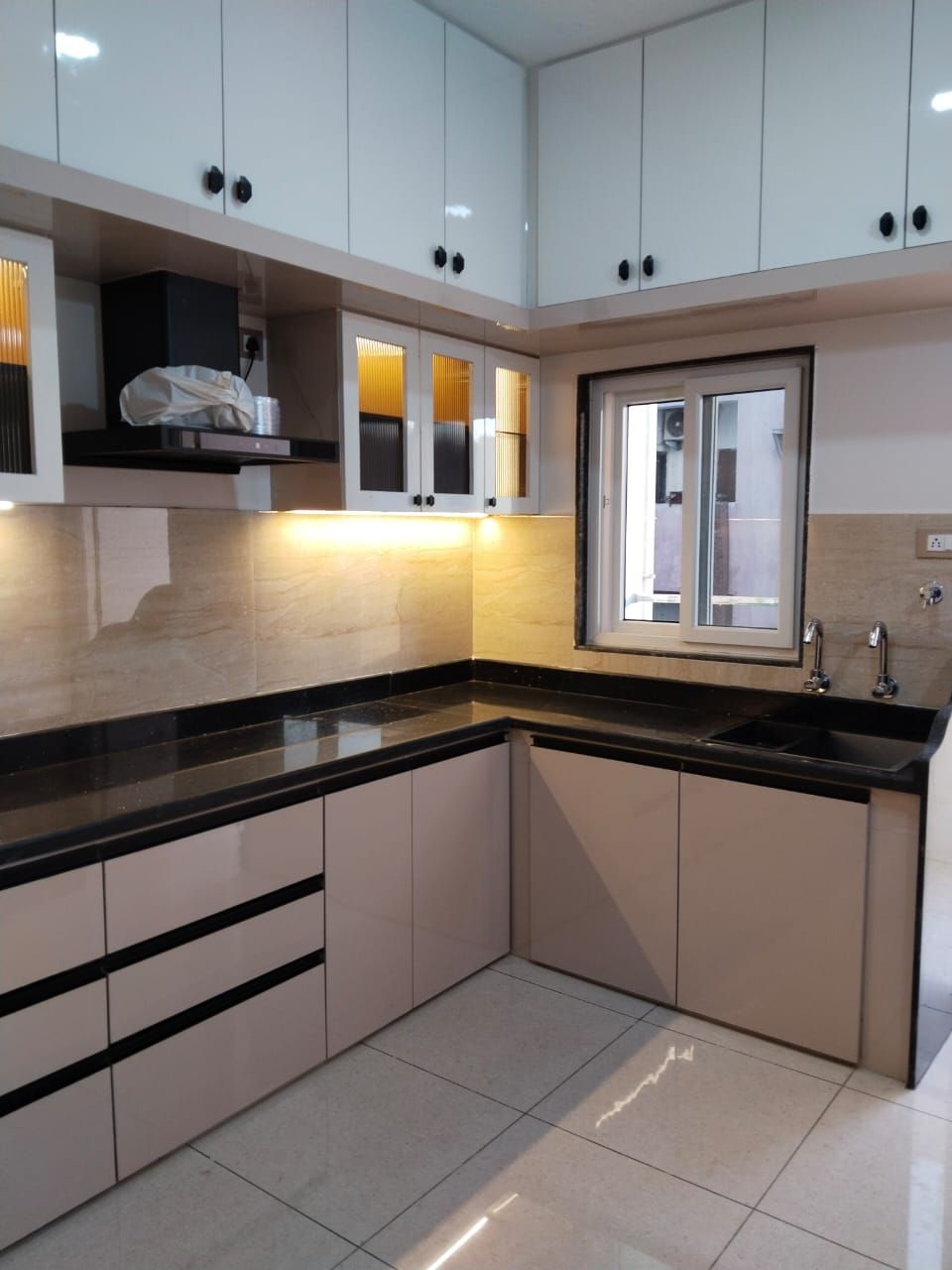 Private kitchen with chimney, sink and storage cabinets at Zuza Homes, Hyderabad